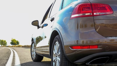 Voiture rouge circulant sur une route au bord d'une rivière