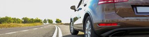 Voiture rouge circulant sur une route au bord d'une rivière
