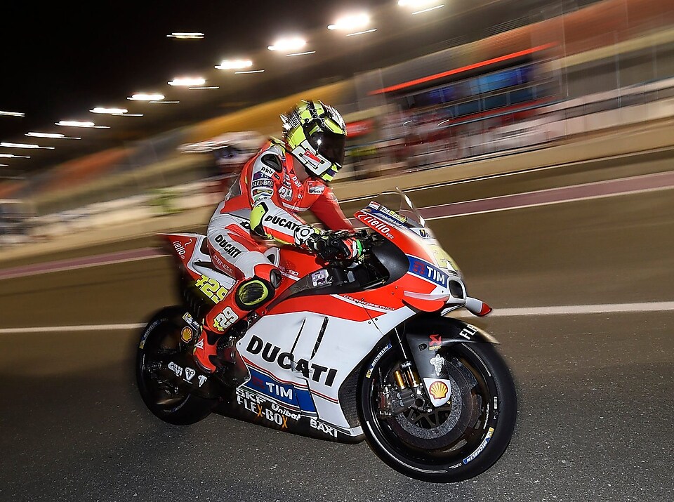 Pilote Ducati roulant vite sur une moto, sur un circuit, de nuit.