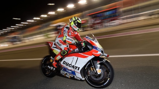 Pilote Ducati roulant vite sur une moto, sur un circuit, de nuit.