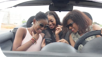 Une jeune femme consulte les instructions affichées sur l'écran de navigation intégré de sa voiture